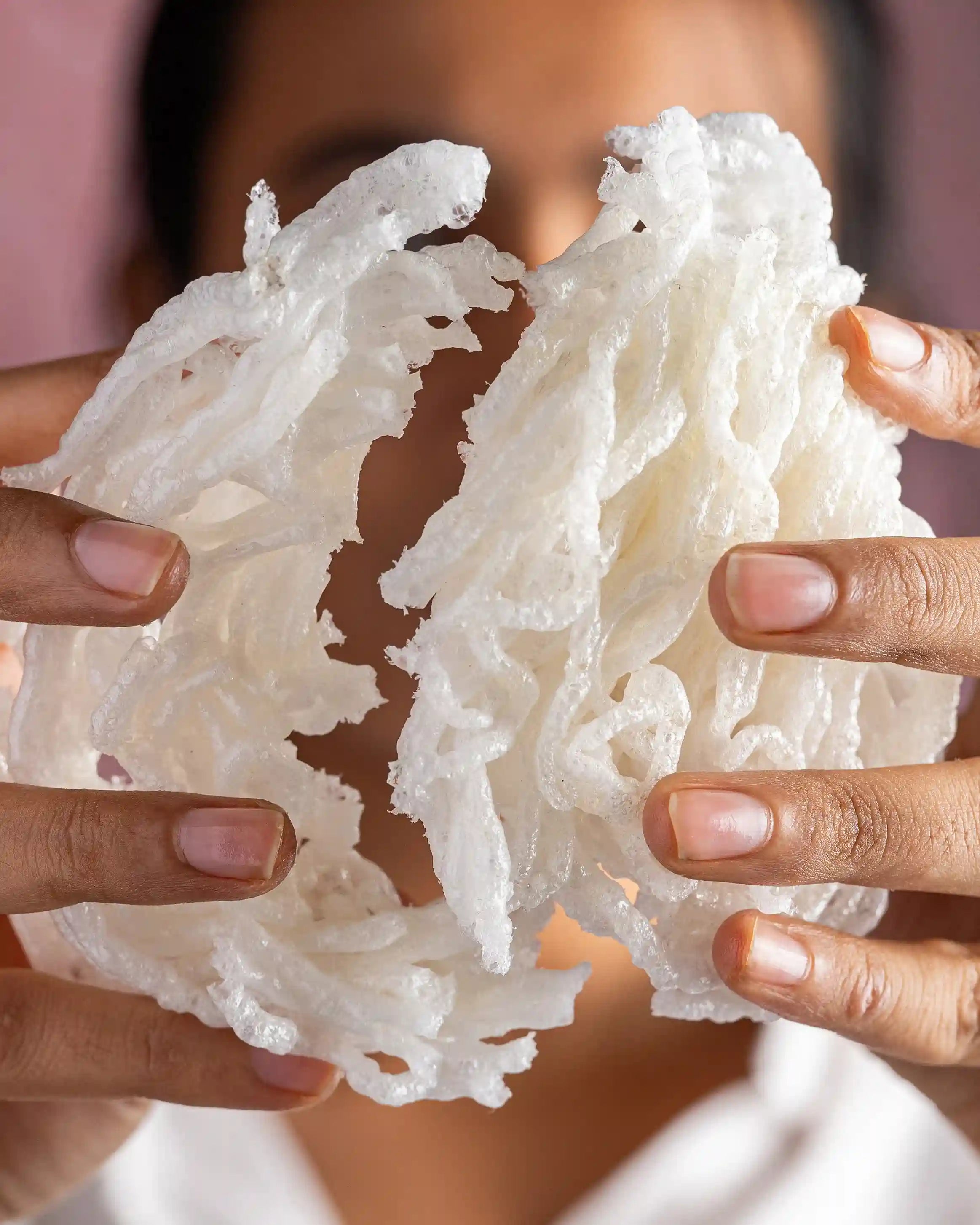 Hands breaking crispy Aazol's Whole Wheat String Papad (Gahu Kurdai)